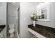Stylish bathroom featuring granite countertops, a shower and decorative flowers at 4604 Townesbury Ln, Raleigh, NC 27612