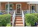 Inviting front porch and entrance featuring brick steps, decorative planters, and a charming front door with wreath at 4604 Townesbury Ln, Raleigh, NC 27612