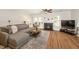 Cozy living room featuring a gray sectional, fireplace, and hardwood flooring, creating a comfortable and stylish space at 4604 Townesbury Ln, Raleigh, NC 27612