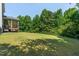 View of the backyard with a large grassy area and mature trees at 486 S Denise Ave, Coats, NC 27521