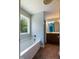 Bright bathroom with a bathtub, large window, and vanity with ample storage at 486 S Denise Ave, Coats, NC 27521