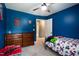 Blue bedroom with a ceiling fan, carpet, Spiderman decor, and wood furniture at 486 S Denise Ave, Coats, NC 27521