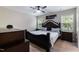Spacious bedroom with a large bed, ceiling fan, natural lighting, and dark wood furniture at 486 S Denise Ave, Coats, NC 27521