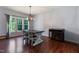 Bright dining room with natural light, wood floors, a modern light fixture, and decorative cabinet at 486 S Denise Ave, Coats, NC 27521