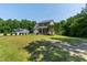 Two-story home with mature trees, green grass, and an American flag at 486 S Denise Ave, Coats, NC 27521