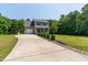 Two-story home with a long driveway, a covered front porch, and landscaped with green shrubbery and rock borders at 486 S Denise Ave, Coats, NC 27521