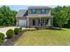 Charming two-story home featuring a well-manicured lawn and a welcoming front porch with rocking chairs at 486 S Denise Ave, Coats, NC 27521