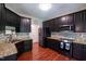 Modern kitchen with granite countertops, black appliances, hardwood floors and stylish backsplash at 486 S Denise Ave, Coats, NC 27521