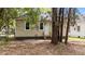 Rear view of home showing the back entrance with wood stairs and light beige siding surrounded by trees at 508 Buena Vista Ave, Rocky Mount, NC 27801