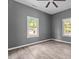 A cozy bedroom with gray walls, ceiling fan, wood-look floors and natural light coming through the windows at 508 Buena Vista Ave, Rocky Mount, NC 27801