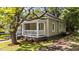 A charming single-story home featuring a welcoming front porch framed by mature trees and lush greenery at 508 Buena Vista Ave, Rocky Mount, NC 27801