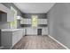 Bright kitchenette with white cabinets and countertops, and attractive wood-look vinyl floors at 508 Buena Vista Ave, Rocky Mount, NC 27801