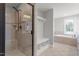 Bright bathroom featuring a glass shower and a soaking tub with tile surround at 513 Lake Gaston Dr, Fuquay Varina, NC 27526