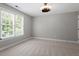 Bedroom features neutral carpet, neutral walls, a ceiling light, and a sunny window at 513 Lake Gaston Dr, Fuquay Varina, NC 27526