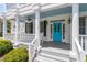 Inviting covered front porch with white pillars, rocking chairs and stylish blue door at 513 Lake Gaston Dr, Fuquay Varina, NC 27526