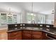 Stylish kitchen with granite countertop and stainless sink, leading to a brightly lit dining space at 513 Lake Gaston Dr, Fuquay Varina, NC 27526