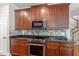 Kitchen boasts granite counters, stainless appliances, and rich wood cabinetry at 513 Lake Gaston Dr, Fuquay Varina, NC 27526