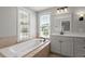 Main bathroom features a large soaking tub beneath two windows and a white vanity at 513 Lake Gaston Dr, Fuquay Varina, NC 27526