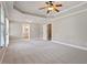 Main bedroom features neutral carpet, tray ceiling with ceiling fan, and access to the ensuite bathroom at 513 Lake Gaston Dr, Fuquay Varina, NC 27526