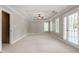 Main bedroom features neutral carpet, tray ceiling with ceiling fan, and access to the backyard through french doors at 513 Lake Gaston Dr, Fuquay Varina, NC 27526