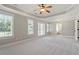 Main bedroom features neutral carpet, tray ceiling with ceiling fan, and a sunny window at 513 Lake Gaston Dr, Fuquay Varina, NC 27526