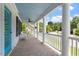 Inviting front porch with white columns, blue ceiling, and tiled floor overlooking the lush yard at 513 Lake Gaston Dr, Fuquay Varina, NC 27526