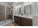 Modern bathroom featuring a dual sink vanity, stylish mirrors and a glass enclosed walk-in shower at 516 Culmore Dr, Fuquay Varina, NC 27526