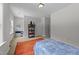 A well-lit bedroom with a colorful rug, shelving unit, and two windows offering a scenic view at 516 Culmore Dr, Fuquay Varina, NC 27526