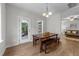 A modern dining area has a wooden table, hardwood floors and sliding door access to the screened porch at 516 Culmore Dr, Fuquay Varina, NC 27526
