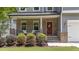 Inviting front porch with brick accents, a red door, and manicured landscaping at 516 Culmore Dr, Fuquay Varina, NC 27526