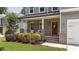 Cozy front porch features brick accents, a red door, and lush landscaping at 516 Culmore Dr, Fuquay Varina, NC 27526