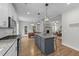 Open-concept kitchen with a gray island, stainless appliances, hardwood floors and an attached dining area at 516 Culmore Dr, Fuquay Varina, NC 27526