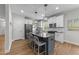 A spacious kitchen features white cabinets, stainless appliances, a gray island and hardwood floors at 516 Culmore Dr, Fuquay Varina, NC 27526