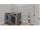 Modern laundry room with stainless steel washer and dryer and overhead wire shelf at 516 Culmore Dr, Fuquay Varina, NC 27526