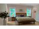 A cozy main bedroom featuring green bedding, bedside tables, and natural light from two windows at 516 Culmore Dr, Fuquay Varina, NC 27526