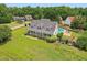 Aerial view showcasing a home with a large front porch, dormers, an in-ground pool, and an outdoor firepit at 5405 Overdale Ln, Raleigh, NC 27603