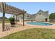 Backyard pool and patio with a pergola swing, next to a large two-story house at 5405 Overdale Ln, Raleigh, NC 27603