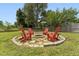 Backyard fire pit with Adirondack chairs surrounded by green grass and large shady trees at 5405 Overdale Ln, Raleigh, NC 27603