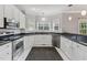Modern kitchen with stainless steel appliances and white cabinets, bathed in natural light at 5405 Overdale Ln, Raleigh, NC 27603