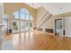 Open-concept living room with hardwood floors, soaring windows, and a staircase to the second floor at 5405 Overdale Ln, Raleigh, NC 27603