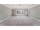Generously sized primary bedroom with tray ceiling, carpet, and plentiful natural light at 5405 Overdale Ln, Raleigh, NC 27603