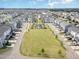 An aerial view of a townhouse community showcasing a large green space and manicured landscaping at 5908 Giddings St, Raleigh, NC 27616