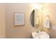Cozy half bathroom with a round mirror, sink and light fixtures at 5908 Giddings St, Raleigh, NC 27616