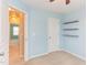 Cozy bedroom features floating shelves, neutral carpet, and a door to another room at 5908 Giddings St, Raleigh, NC 27616