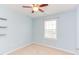 Light blue bedroom features a ceiling fan, window with blinds, and carpeted floors at 5908 Giddings St, Raleigh, NC 27616