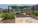 Lush community garden featuring raised beds, a shaded picnic area, and artistic details, creating a vibrant green space at 5908 Giddings St, Raleigh, NC 27616