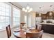 Cozy dining area featuring a wooden table, chandelier, and large windows at 5908 Giddings St, Raleigh, NC 27616