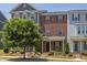 Charming brick townhome featuring a well-manicured front yard with verdant landscaping and a quaint covered entry at 5908 Giddings St, Raleigh, NC 27616