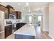 Modern kitchen with stainless steel appliances, granite countertops, and dark wood cabinets, open to the living area at 5908 Giddings St, Raleigh, NC 27616