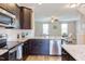 Modern kitchen featuring stainless steel appliances, granite countertops, and dark wood cabinetry at 5908 Giddings St, Raleigh, NC 27616